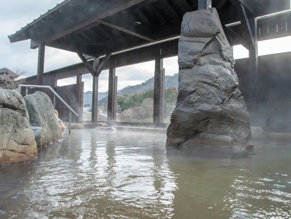 永源寺溫泉八風之湯露天浴池,石造浴槽面向愛知川與山林