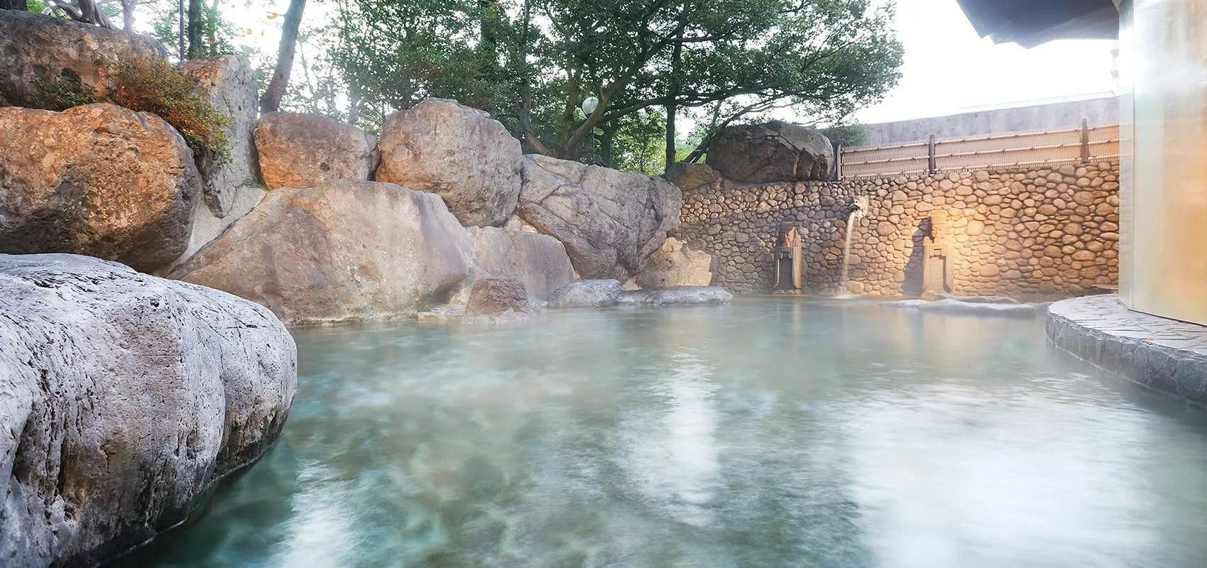 水明館山水閣野天浴池,以巨岩與樹木包圍露天浴槽