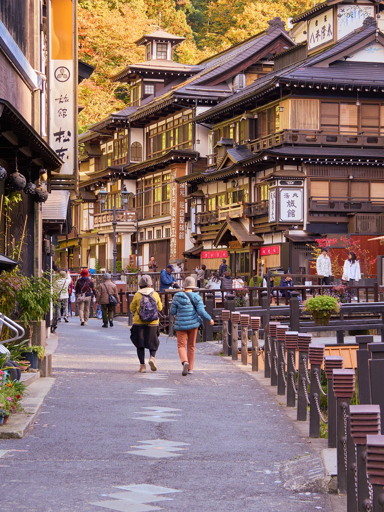銀山溫泉主步道兩側的多層木造旅館與行人